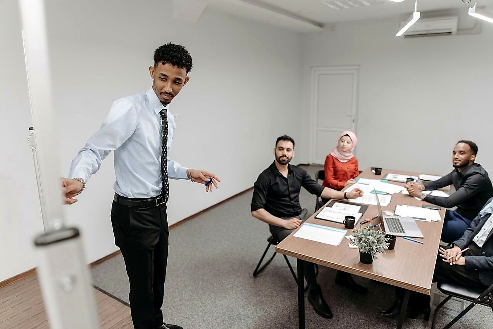 Free A diverse team collaborates in a modern office setting, showcasing teamwork and communication. Stock Photo